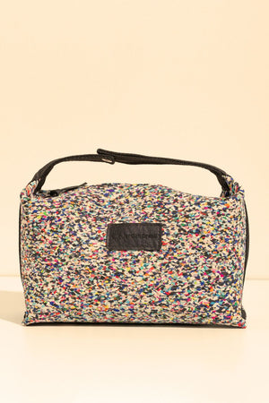 Bolsa-Nécessaire da Jardim Brasil fechada, com estampa floral colorida e alça preta, em fundo bege.